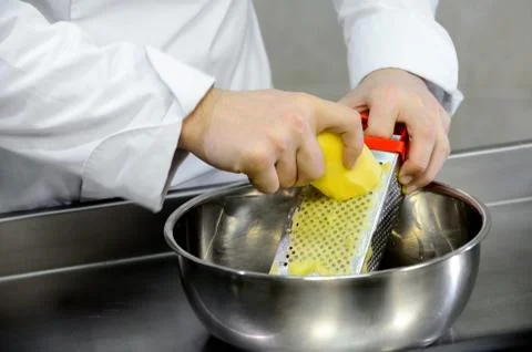 Shredding potatoes on a grater Stock Photos