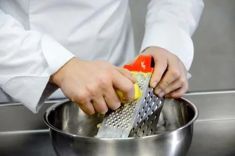 Shredding potatoes on a grater Stock Photos