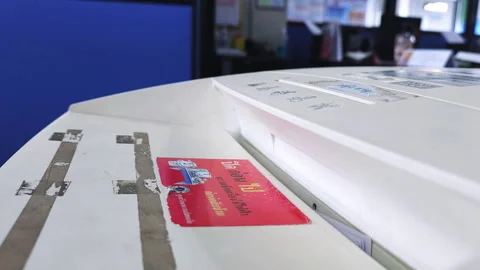 Shredding a stack of documents using an eletrical paper shredder inside an Stock Footage 256299967