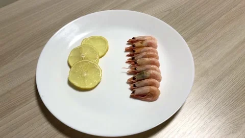 Shrimp and sliced lemon on a white plate. Stock Footage 132393358