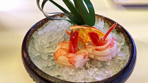 Shrimp appetizer served over crushed ice with garnish in restaurant dish Stock Footage 325057864