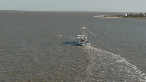 A shrimp boat pulls nets off the coast of South Carolina in this aerial view. Stock Footage 143482751