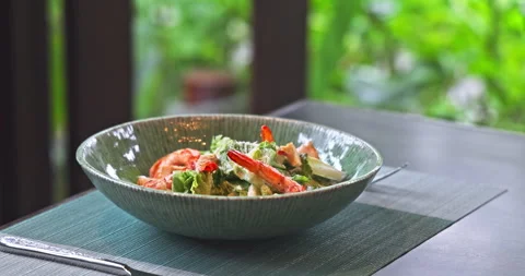 Shrimp Caesar salad served in ceramic bowl on restaurant table Stock Footage 345102661