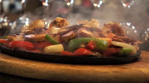 Shrimp fajita sizzling in pan on wood hot plate Stock Footage