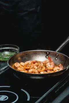 Shrimp on frying pan. Thermal processing of food. Electric cooker in a Stock Photos