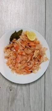 Shrimp shell and head waste after eating on a white plate Stock Photos