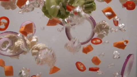 Shrimps fall into boiling water with vegetables. Cooking soup. Side view. Slow Stock Footage 124308343