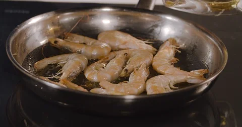 Shrimps fried in a pan in the kitchen. The fire is burning in the pan. Stock Footage 124006613