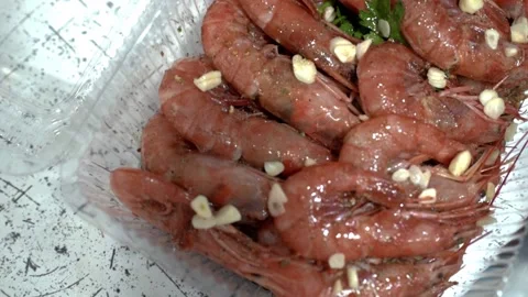 Shrimps in plastic box. Restaurant chef sprinkles shrimp with chopped garlic. HD Stock Footage 141744666