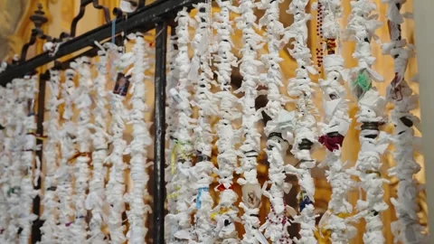 Shrine racks hold countless white paper wishes, with folded prayers and colorful Stock Footage 348032046