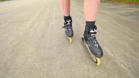 Shuffle inline skating on way in pine forest. Mans legs roller skating on the as Stock Footage 76059368