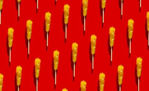 Shugar yellow candy pattern flat lay on red background. Christmas, new year Stock Photos