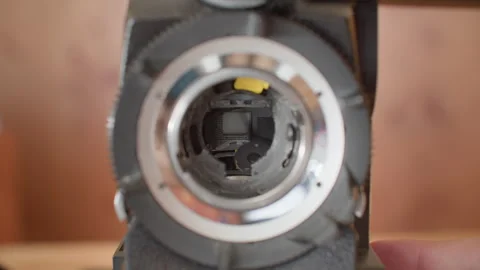 Shutter mirror of a super 16mm analog film camera spinning, revealing filmstrip Stock Footage 297786549