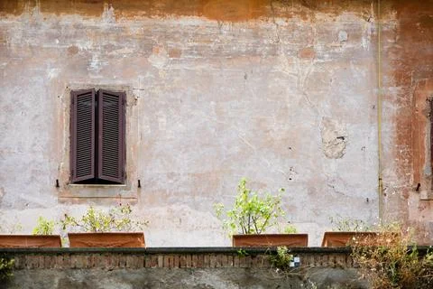 Shuttered window and aged wall with ledge in Rome, Italy Stock Photos