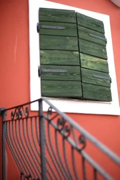 The shuttered window on the bright facade of the old house. Stock Photos