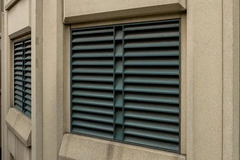 Shuttered windows on a modern building facade showing a gray concrete struc.. Stock Photos