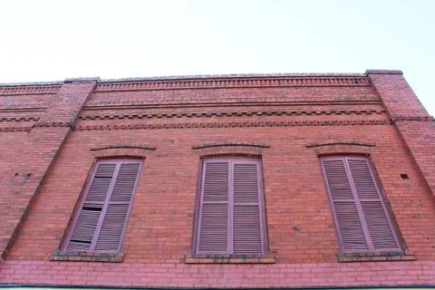 Shuttered windows of an old brick building Stock Photos