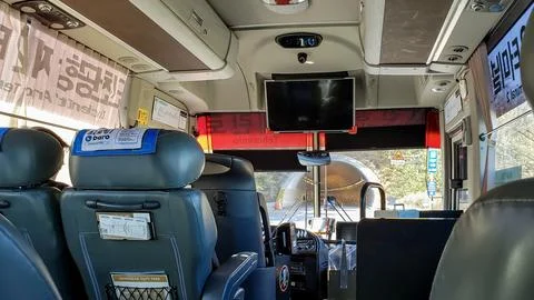 Shuttle bus in motion and approaching a tunnel entrance Stock Photos