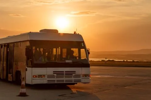 Shuttle buses at the stop of the airport in the rays of the setting sun Stock Photos