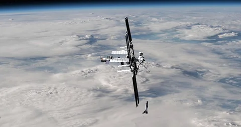 Shuttle moves into docking position with the ISS over atmospheric cloud cover Stock Footage
