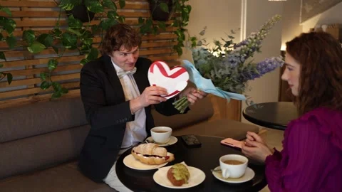 Shy man giving gift on date Stock Footage 328145864