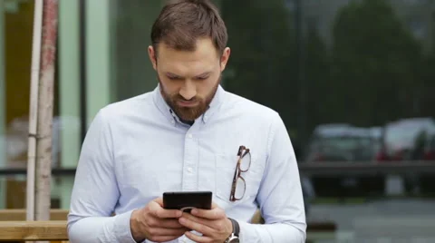 Shy young man using his tablet in the street Stock Footage 64112903