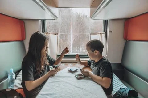 Sibling Bonding Time : In the cozy train compartment, two young individuals Foto stock