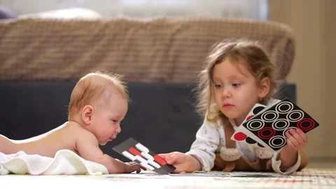 Sibling Card Presentation. Young Siblings Interact Peacefully While Examining Stock Footage 331200967