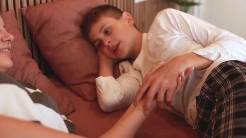 Sibling pair resting side by side, softly holding hands, reflecting profoun.. Vídeo Stock 305863655