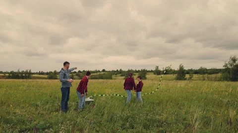 Siblings and father, soaring kite in breeze, countryside delight, precious Stock Footage 314289837