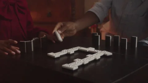 Siblings and friends having fun playing dominoes together inside Stock Footage 319914932