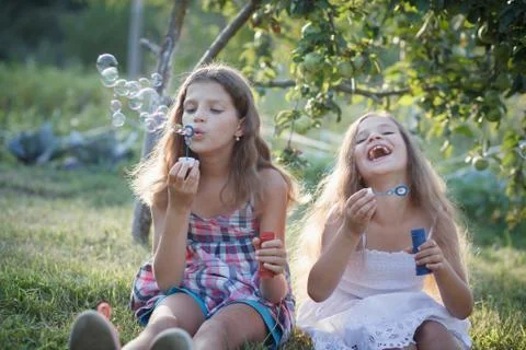 Siblings blowing soap bubbles Stock Photos