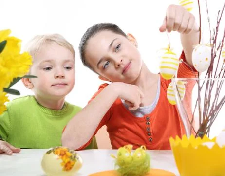 Siblings decorates Easter eggs  Stock Photos