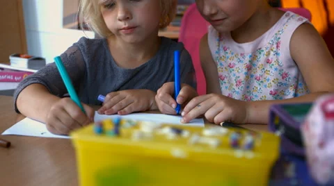 Siblings drawing with colored pencils while sitting at desk at home in nursery Stock Footage 66299101