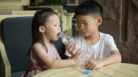 Siblings drinking water from bottle Stock Footage 67580208
