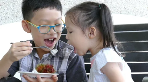Siblings eating fruit together Stock Footage 68223028