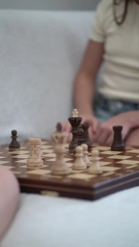 Siblings enjoy a thoughtful chess game indoors 스톡 동영상 342771973