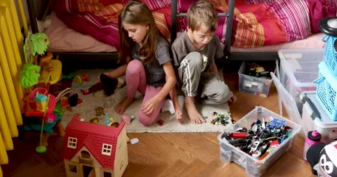 Siblings enjoying creative playtime with building blocks indoors Stock Footage 295277634