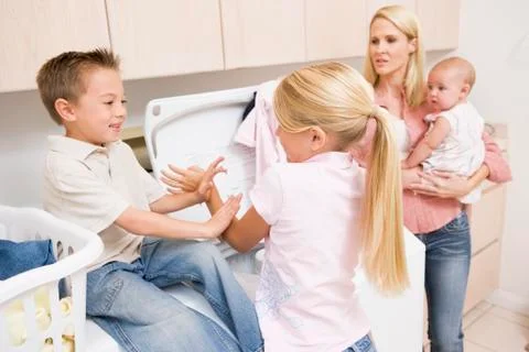 Siblings fighting while doing laundry Foto stock