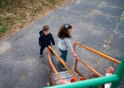 Siblings have fun at the playground in the fall Stock Photos