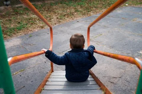 Siblings have fun at the playground in the fall 库存照片