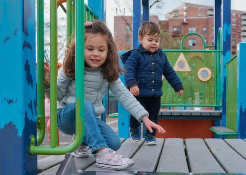 Siblings have fun at the playground in the fall Stock Photos