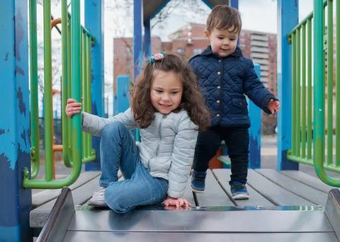 Siblings have fun at the playground in the fall Stock Photos