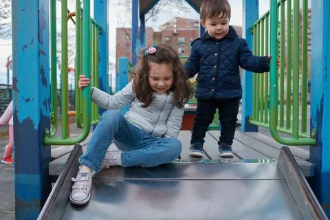 Siblings have fun at the playground in the fall Stock Photos