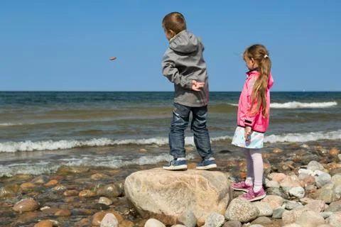 Siblings having fun at the beach Stock Photos