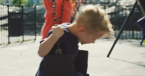Siblings having Fun with chain swing on outdoor playground Stock Footage 116114762