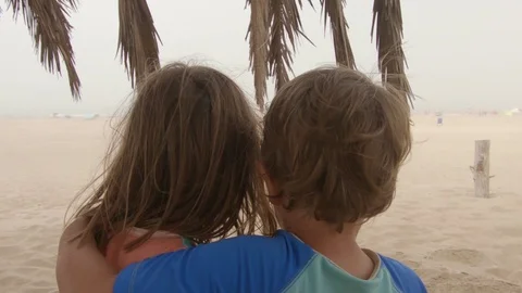 Siblings hugging at the beach Stock Footage 130097864