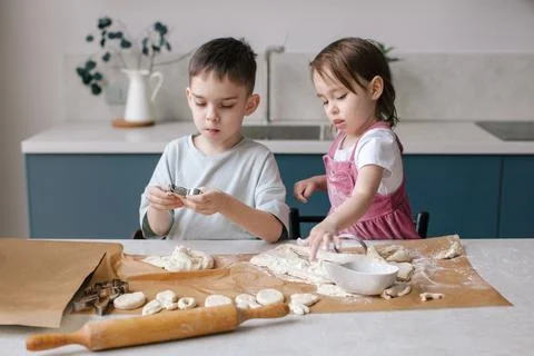 Siblings making cookies, preparing Easter. Stock Photos