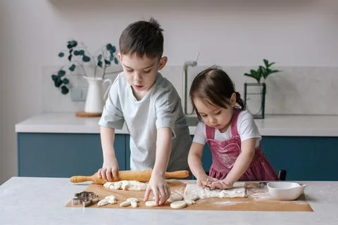 Siblings making cookies, preparing Easter. Stock Photos