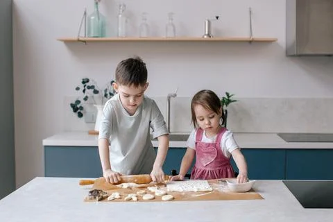 Siblings making cookies, preparing Easter. Stock Photos